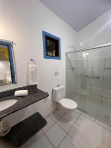 ein Bad mit einem WC und einer Glasdusche in der Unterkunft Zil Hospeda in Pipa