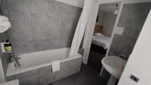 y baño con bañera, aseo y lavamanos. en Hôtel Le Verger en Saint Laurent Nouan