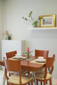 a dining room table with chairs and a wooden table with plates and bowls at Magico Home City Heart Luxury Appartment in Alexandroupoli