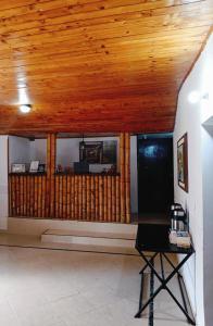 Habitación con techo de madera y mesa. en Finca Hotel Amanecer del Cafeto, en Montenegro