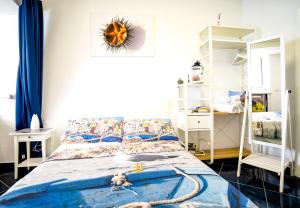 a bedroom with a bed with a blue comforter at La terrazza di Maria in Procida