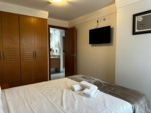Un dormitorio con una cama y un televisor de pantalla plana. en Alugueasy - Brasília Lider, 13º e 14º Andar, en Brasilia