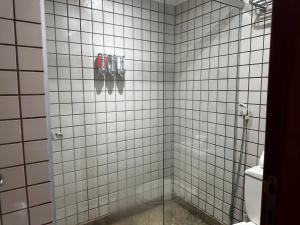 y baño con ducha y paredes de azulejos blancos. en Alugueasy - Brasília Lider, 13º e 14º Andar, en Brasilia