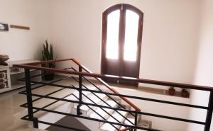a stairwell with a window and a wooden railing at Miras Guest House in Praia