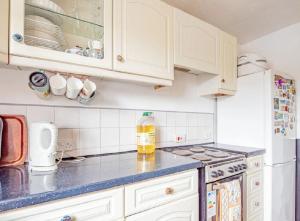 a kitchen with white cabinets and a blue counter top at Home Away Home near Heathrow Airport in Cowley
