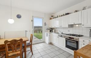 a kitchen with white cabinets and a table and a dining room at Nice Home In Schenkendöbern With Wifi in Schenkendöbern
