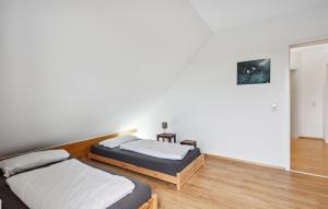 Duas camas num quarto com paredes brancas e pisos em madeira em Stunning Home In Schenkendbern With Wi-fi em Schenkendöbern