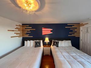 2 camas num quarto com uma parede azul em Acadia Ocean View Hotel em Bar Harbor