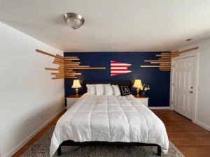 a bedroom with a large bed with a blue wall at Acadia Ocean View Hotel in Bar Harbor