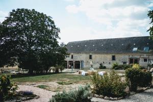 un antiguo granero de piedra con un jardín delante de él en Le Duplex de l'Etoile home cinéma jacuzzi et sauna privatif, en Longmesnil