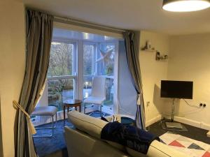 a living room with a couch and a large window at Lawn View Apartment in Dawlish