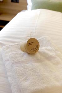 a small cup on top of a white bed at Harmony - Schlafen im Stadtzentrum in Meiningen +2 photos