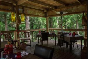 a screened in porch with tables and chairs and trees at KAZ INSOLITE in Saint-Louis