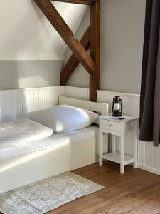 a bedroom with a white bed and a table at Rustic Charm - Cottage by Comfort Housing in Kolonie Neudöberitz