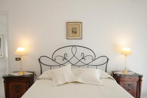 um quarto com uma cama branca com duas mesas de cabeceira em Donna Luisa Suite 9 Amalfi sea view - free parking em Scala