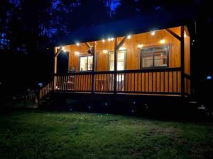 una pequeña casa con luces en el porche por la noche en Zen of the Woods Tiny Cabin in Okemo Valley, en Chester