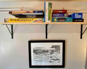 un estante con libros y una foto en una pared en Zen of the Woods Tiny Cabin in Okemo Valley, en Chester