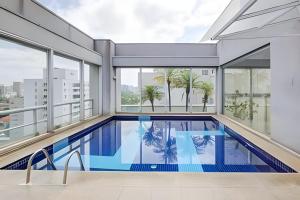 una piscina cubierta en un edificio con ventanas en GetaFlat 404 George Itaim Bibi, en São Paulo