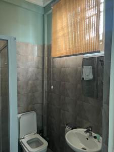a bathroom with a toilet and a sink at Jackie Grand Hotel in Cape Coast