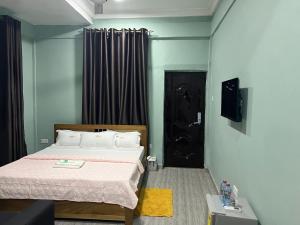una camera con un letto e una porta nera di Jackie Grand Hotel a Cape Coast