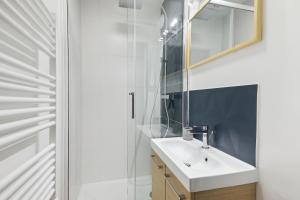 a bathroom with a sink and a mirror at Appartement elegant- Parc Saint Cloud in Sèvres