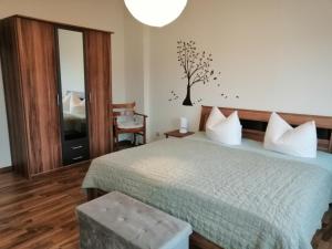 a bedroom with a bed and a tree on the wall at Ferienwohnung HARZgeNUSS in Wernigerode