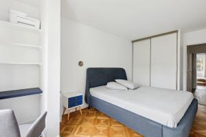 a small bedroom with a bed and a chair at Appartement elegant- Parc Saint Cloud in Sèvres