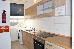 a kitchen with wooden cabinets and a sink and a dishwasher at GASTEM UG in Berlin