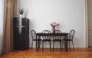 mesa de comedor con sillas y nevera en Vintage Dream Apartment, en Oradea