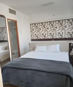 ein Schlafzimmer mit einem großen weißen Bett und einem Spiegel in der Unterkunft Get a Flat 1403 localização Nobre in São Paulo