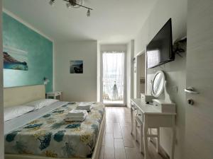 a bedroom with a bed and a desk and a television at Fezzano / Portovenere Stilish double rooms with sea view, balcony or small courtyard in Fezzano