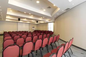 an empty room with red chairs and a screen at Get a Flat 1403 localização Nobre in Sao Paulo