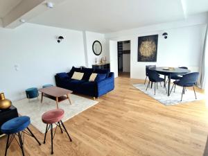 a living room with a blue couch and a table at Le Rooftop Suresnes Paris La Défense - Spacieux Duplex 100 m2 Terrasse in Suresnes