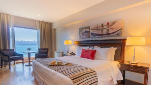 a hotel room with a bed with a tray of food on it at Alma Del Lago Suites & Spa in San Carlos de Bariloche +37 photos
