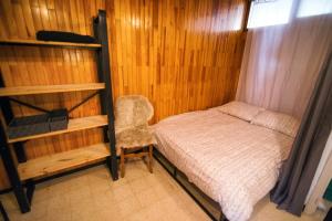 ein kleines Schlafzimmer mit einem Bett und einem Stuhl in der Unterkunft Les Tilleuls 24 - balcon vue montagne in Orcières