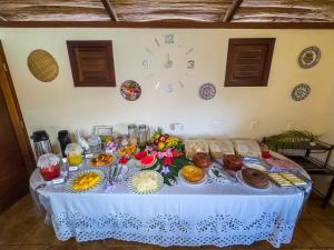 una mesa con comida en ella con un reloj en la pared en Pousada Berro do Jeguy, en Pipa