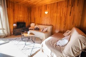 ein Wohnzimmer mit 2 Betten und einem Sofa in der Unterkunft Les Tilleuls 24 - balcon vue montagne in Orcières