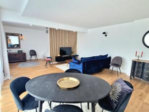 a living room with a table and chairs at Le Rooftop Suresnes Paris La Défense - Spacieux Duplex 100 m2 Terrasse in Suresnes