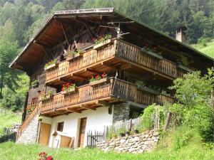 a house with a balcony with flowers on it at Ausser Brugghof in Senales