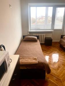 1 dormitorio con 2 camas y ventana en Дешеві кімнати біля парку, en Ivano-Frankivsk