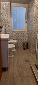 baño con lavabo y aseo y ventana en Seaside apartment en Krk