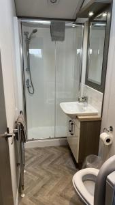 La salle de bains est pourvue d'une douche, d'un lavabo et de toilettes. dans l'établissement 2-Bed Lodge Near Garstang and Poulton-Le-Fylde, à Preston