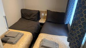 a small room with two beds in a small room at Cosy 3-Bed hot tub Lodge in Pr3 in Preston