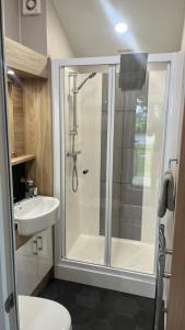 a bathroom with a shower and a toilet and a sink at Cosy 3-Bed hot tub Lodge in Pr3 in Preston