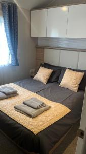 een slaapkamer met een bed met twee handdoeken erop bij Cosy 3-Bed hot tub Lodge in Pr3 in Preston