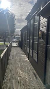a wooden boardwalk next to a building with windows at Pet Friendly 2-Bed Lodge near Preston & Blackpool in Preston
