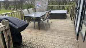 a patio with a table and chairs on a deck at Pet Friendly 2-Bed Lodge near Preston & Blackpool in Preston