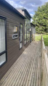 a house with a wooden deck on the side of it at Pet Friendly 2-Bed Lodge near Preston & Blackpool in Preston