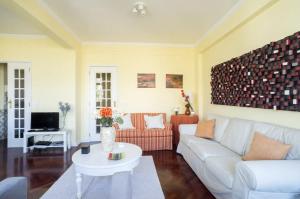 ein Wohnzimmer mit einem Sofa und einem Tisch in der Unterkunft Spacious Apartment in Belém in Lissabon