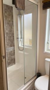 bagno con doccia in vetro e servizi igienici. di Immaculate 3-Bed Lodge in Out Rawcliffe a Great Eccleston